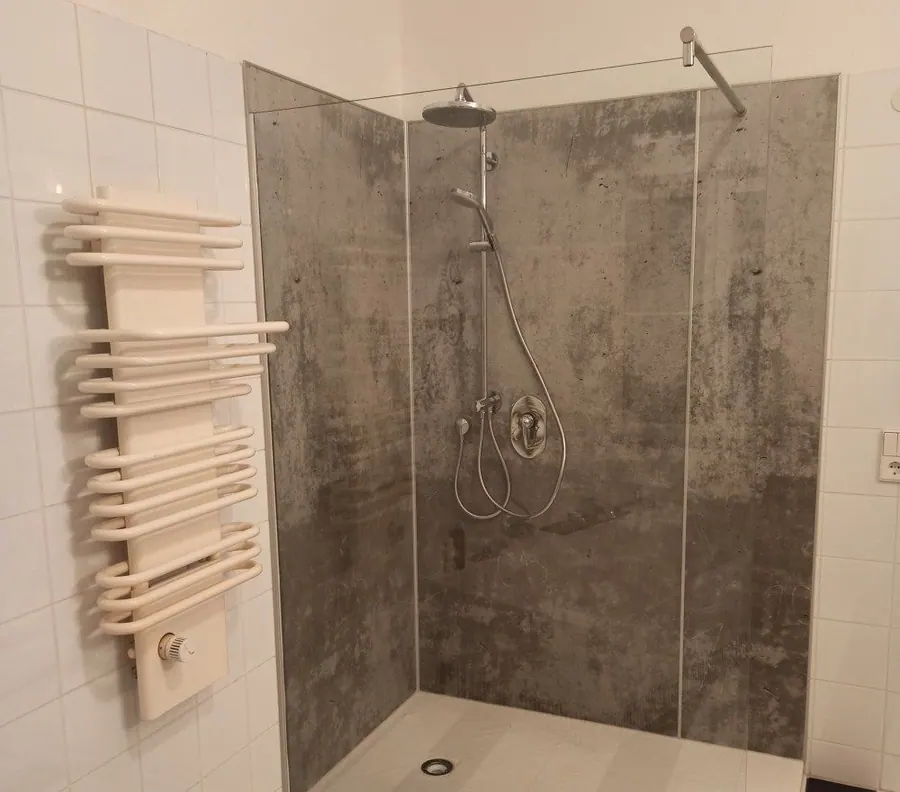 Neue bodennahe Dusche mit fugenlosen Wandplatten in Sichtbeton-Optik, saniert von Sickinger in Hechingen