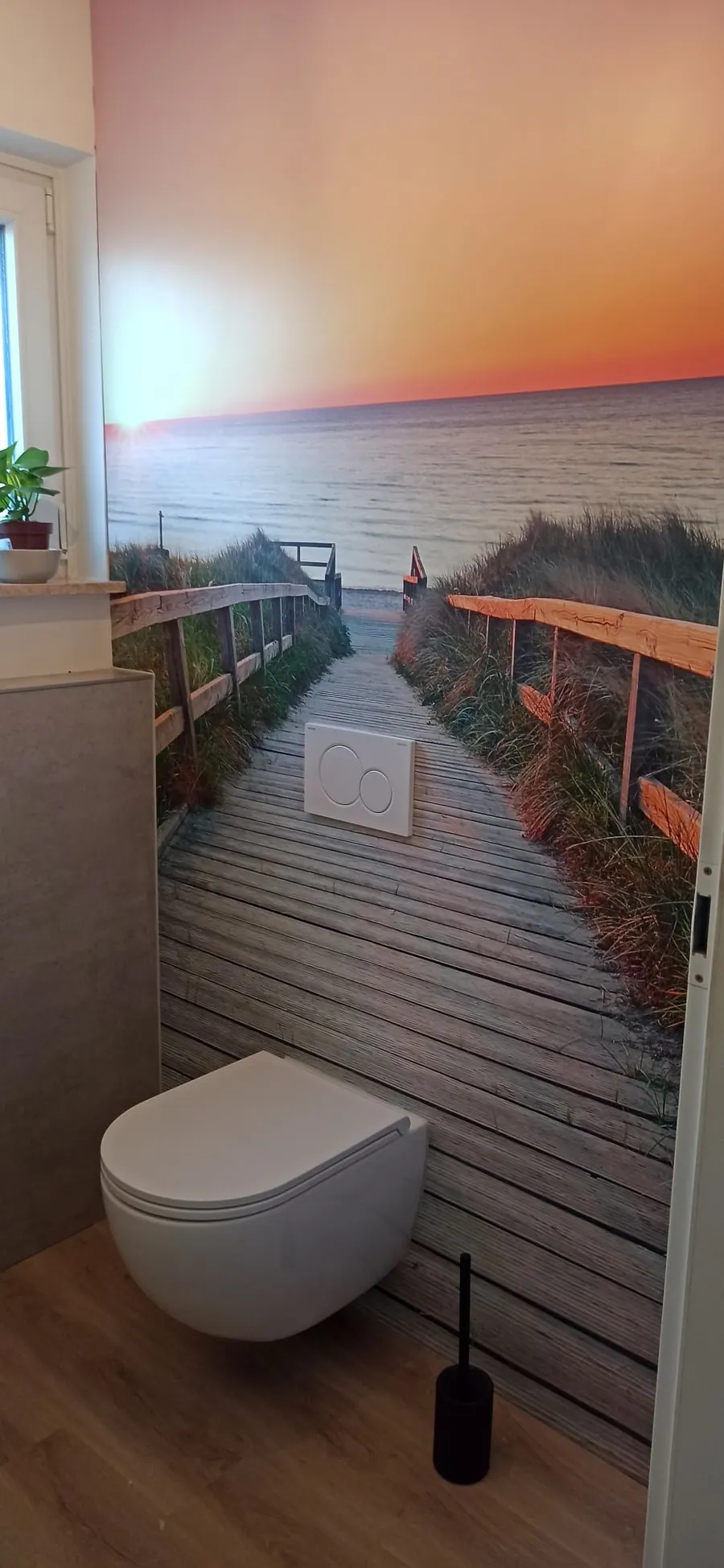 Gäste-WC mit fugenloser Motivwand Strandsteg und wandhängendem WC